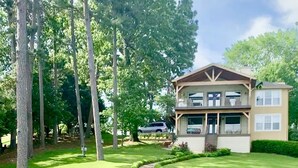 A two-story house with a stone pathway leading to a wooden bridge over a stream. - Hamilton Happy Place (million dollar view) - Lake Retreat (Hot Springs)