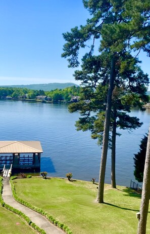 A lakeside view with a building featuring a dock and a grassy area. - Hamilton Happy Place (million dollar view) - Lake Retreat (Hot Springs)