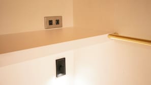 Una pared con interruptor de luz y enchufes.