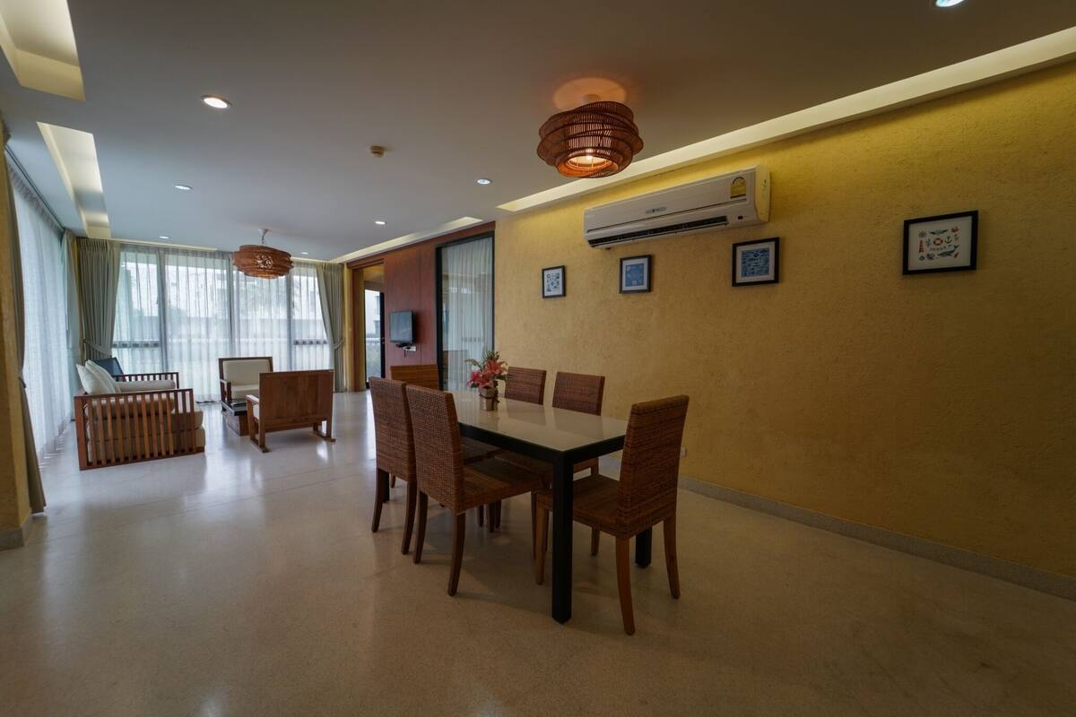 A dining area with a table and chairs, a sofa, and a TV.