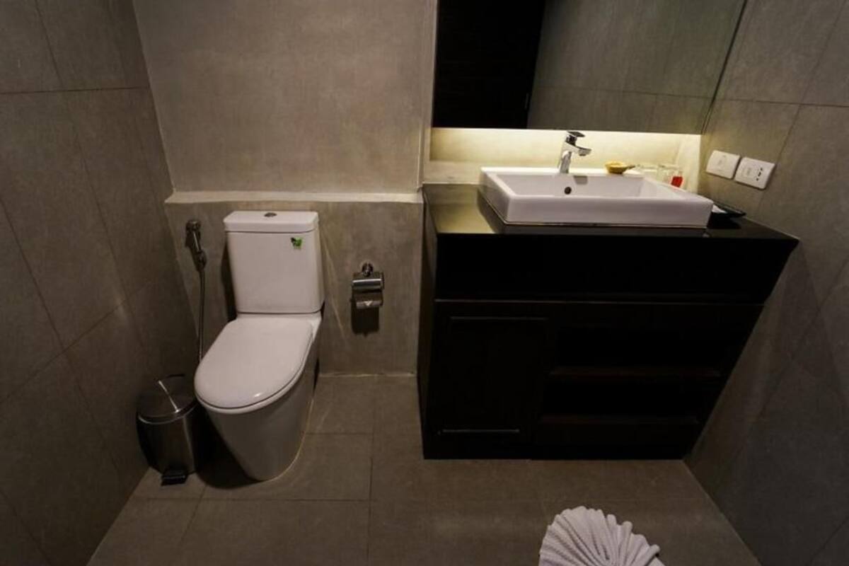 A modern bathroom with a toilet, sink, and mirror.