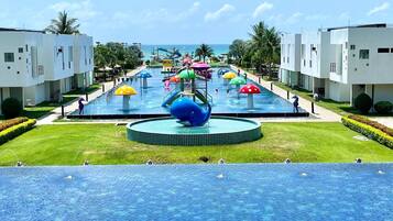 A resort with multiple swimming pools, water slides, and a central water feature.