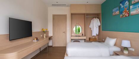 A hotel room with a TV, a desk, a bed, a wardrobe, and a bathroom mirror.