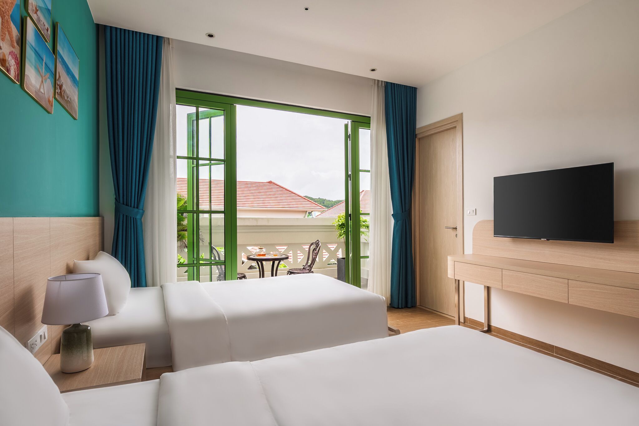 A hotel room with two beds, a TV, a lamp, and a view of the outside.