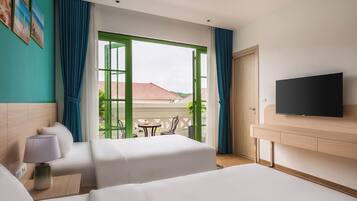 A hotel room with two beds, a TV, a lamp, and a view of the outside.