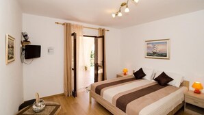 A bedroom with a bed, bedside lamps, a television, a painting, and a window with curtains. - Villa Barbara (Zupa dubrovacka)