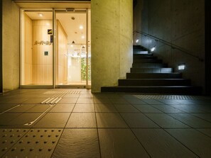 Een hotelentree met een houten interieur, een trap en een betegelde vloer.