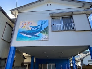 A building with a mural of a whale and flowers on the side.