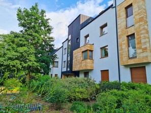 A modern residential building with multiple balconies, large windows, and a well-maintained garden area. - RS2.29 - Sienkiewicz Residence (RS1, RS2) (Swinoujscie)