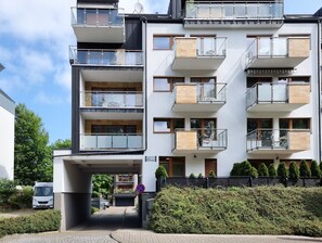 A multi-story residential building with balconies, a covered entrance, and a parking area. - RS2.29 - Sienkiewicz Residence (RS1, RS2) (Swinoujscie)