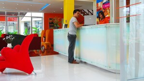 Uma área de recepção com divisória de vidro, uma cadeira vermelha e design de interiores moderno.