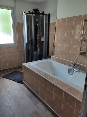Een bad/douchecombinatie, een haardroger, handdoeken