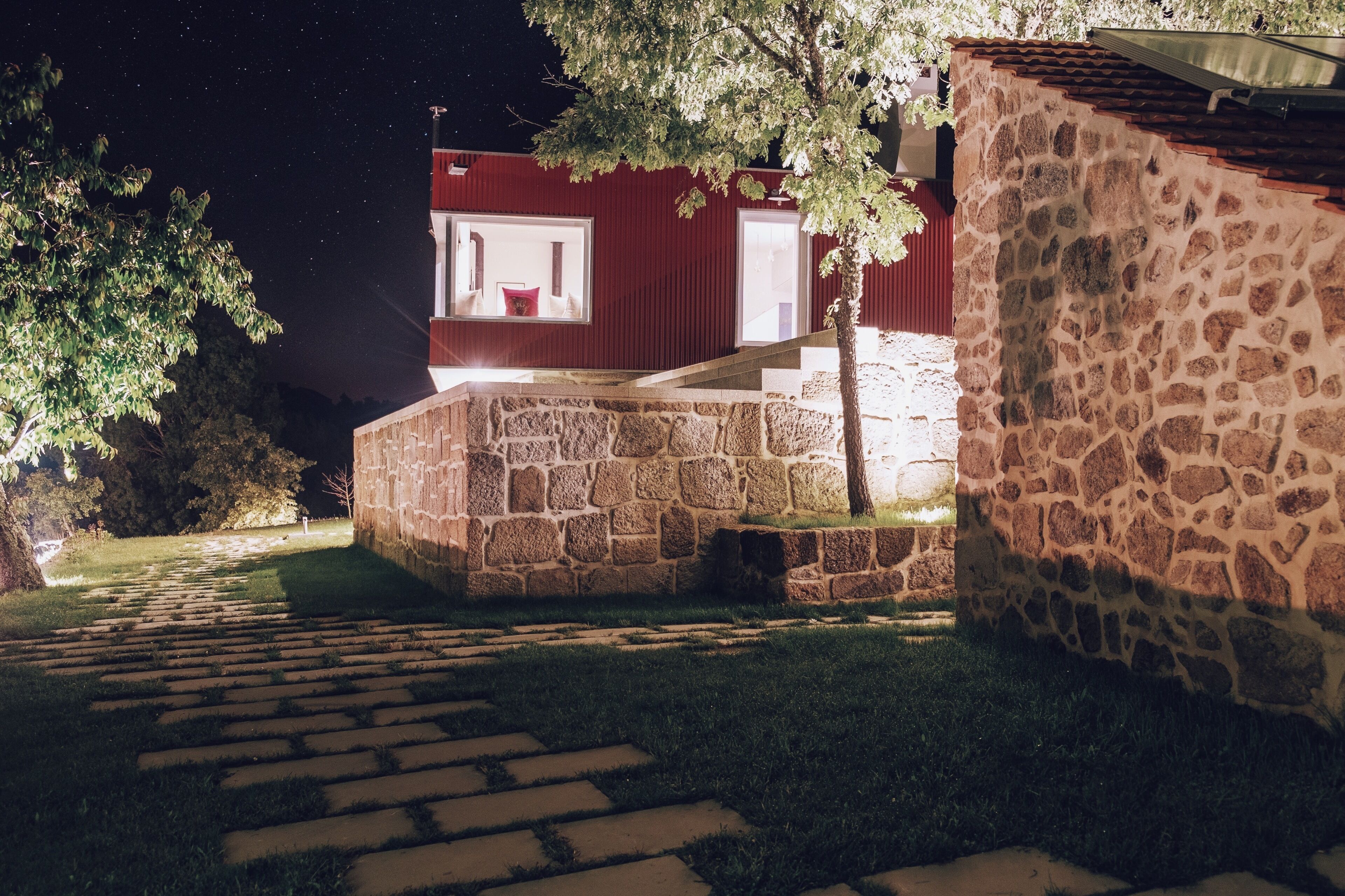 Um edifício de pedra com fachada vermelha e escadaria que leva a uma porta.
