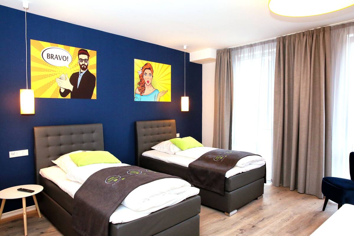 Ein Hotelzimmer mit zwei Betten, einem kleinen Tisch und einem Stuhl.