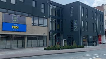 A modern building with a large blue sign for 'TEDi' and a smaller sign for 'APART GO'.