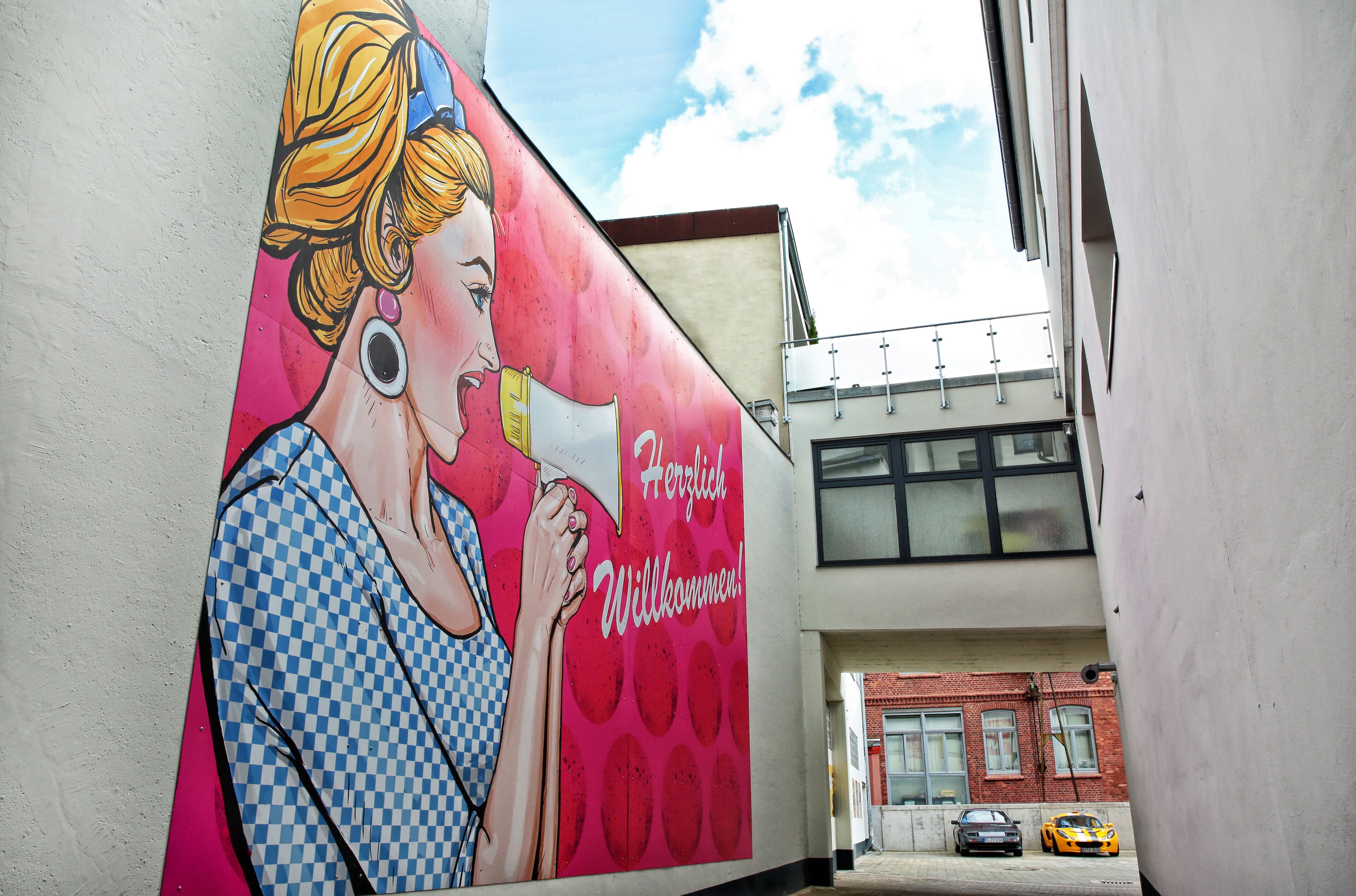 A mural on a building wall with a woman and text.