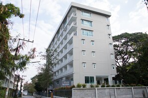 Un hotel de varios pisos con balcones, un cartel con el nombre Nivas y una entrada con portón.