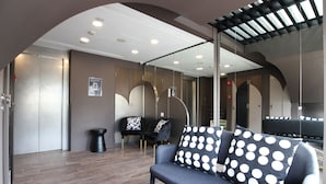 A modern interior with a sofa, chairs, and a glass partition. - ST Signature Bugis Beach, DAYUSE, 5 hours: 4PM-9PM (Singapore)