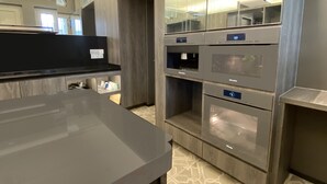 Una cuina moderna amb electrodomèstics integrats, un taulell negre i un terrapatí amb un disseny original.