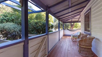 Relax on the covered porch, surrounded by lush gardens and comfortable seating.