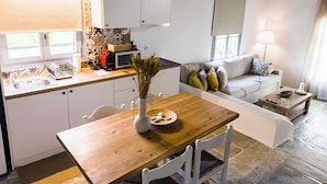Un espacio habitable pequeño con kitchenette, comedor y zona de estar.