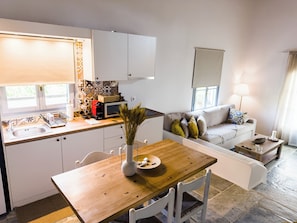Um espaço compacto com cozinha compacta, área de refeições e sala de estar.