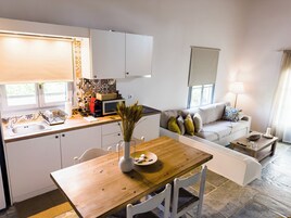Un espacio habitable pequeño con kitchenette, comedor y zona de estar.