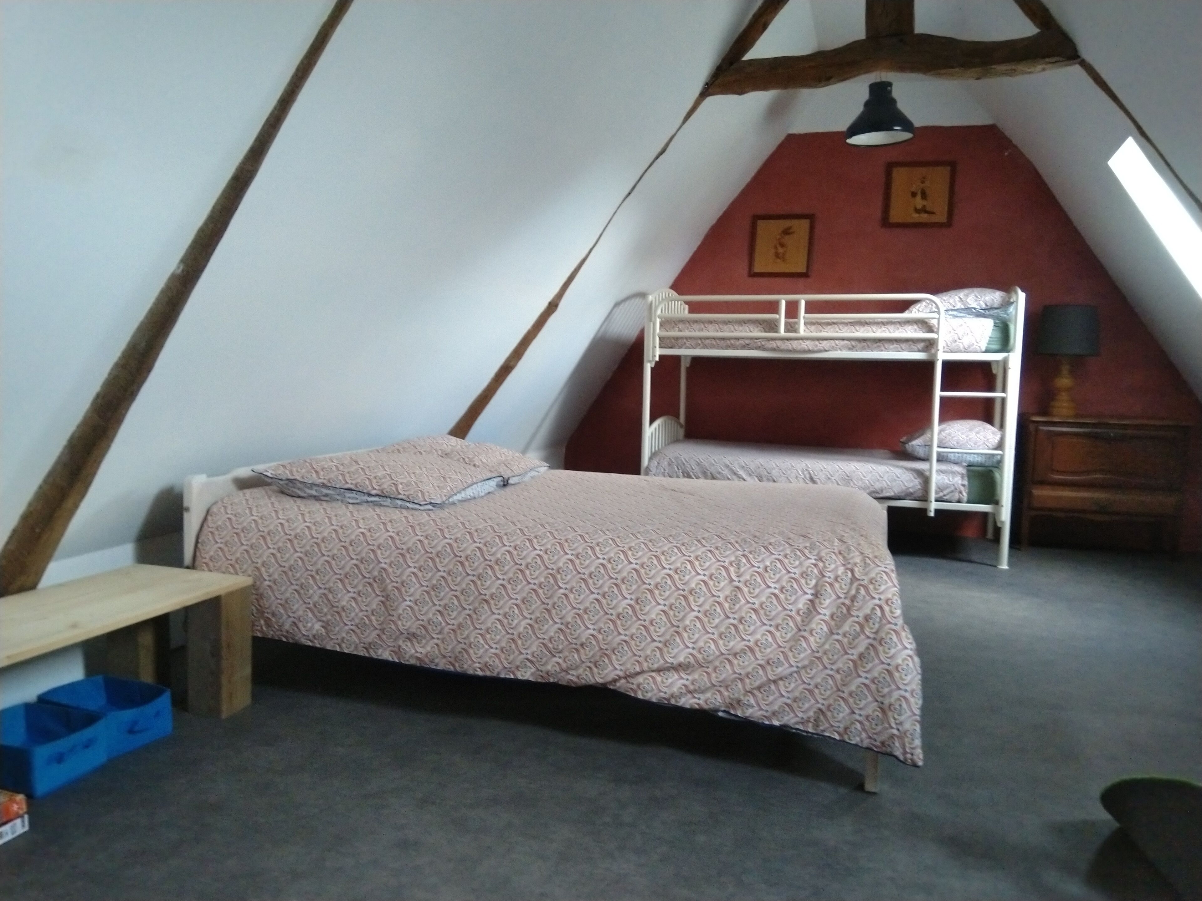 Een slaapzaal met stapelbedden, een bureau en een lamp.
