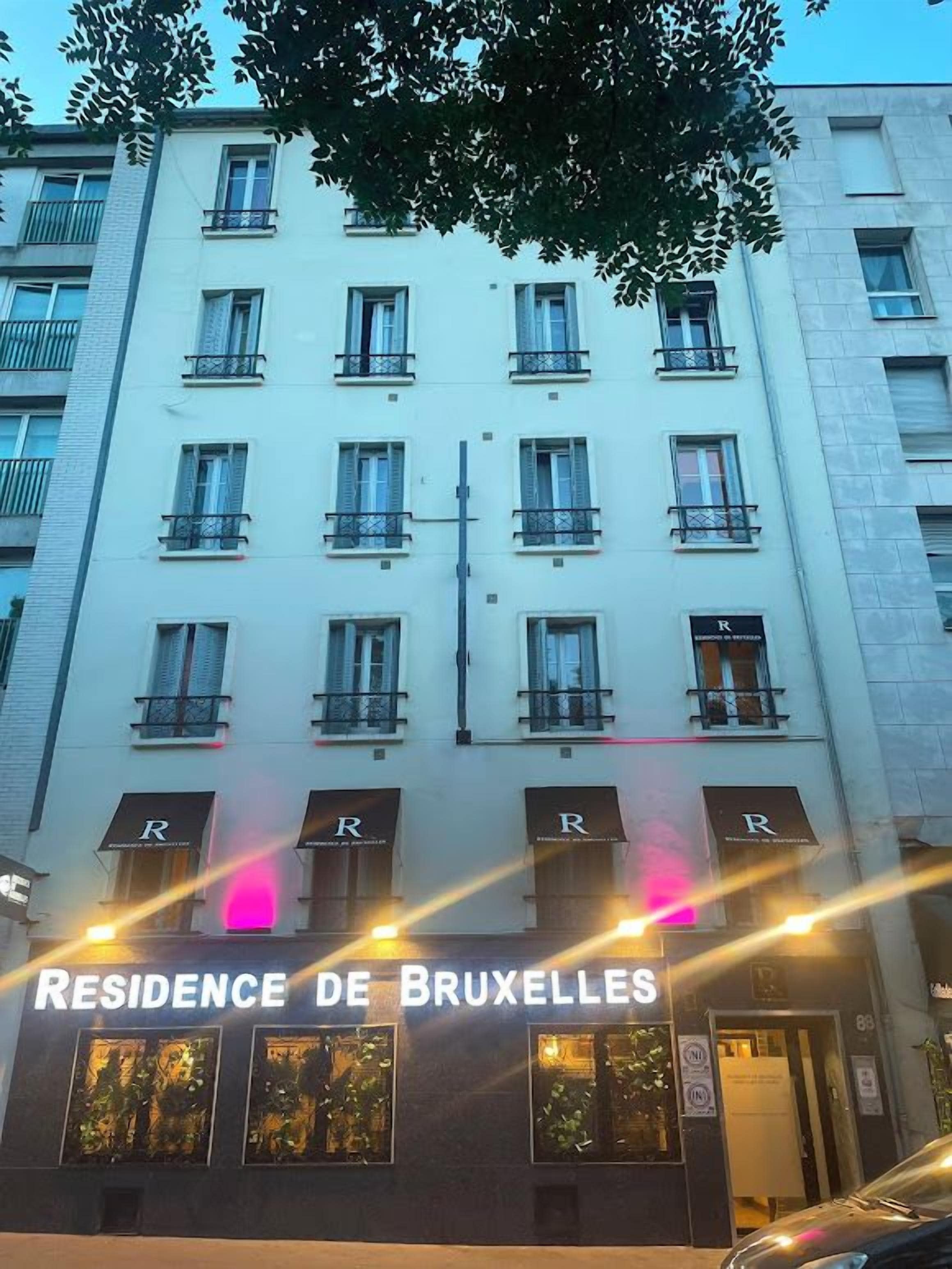 A multi-story building with the sign 'RESIDENCE DE BRUXELLES' indicating it is a hotel.