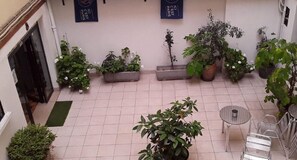 Relax in this serene courtyard, surrounded by lush greenery and a tranquil atmosphere.