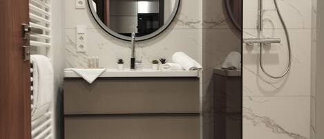 Une salle de bain moderne avec un sol en marbre, un miroir rond, un lavabo avec une serviette et un espace douche.