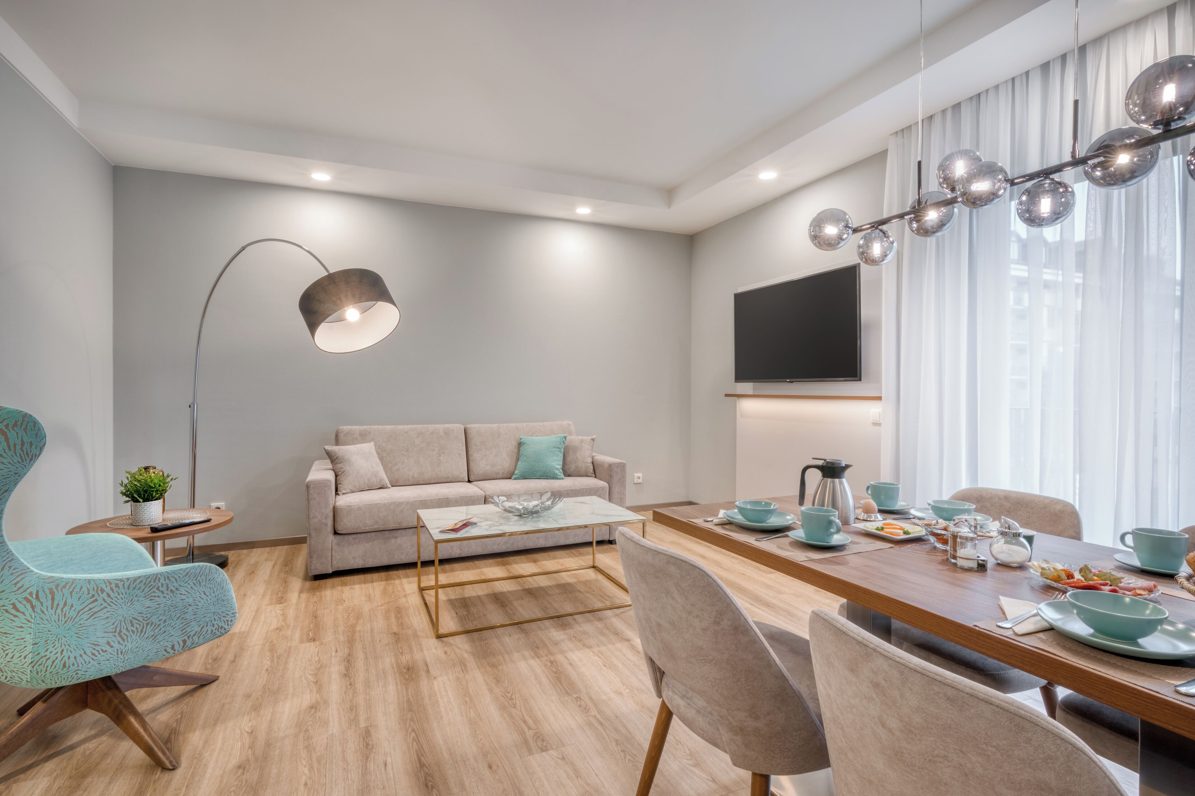 Un salon moderne avec un canapé, une table basse et une table à manger préparée pour le petit-déjeuner.