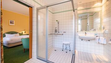 A hotel bathroom with a shower, sink, and toilet.