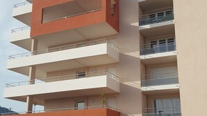 Un edificio de varios pisos con balcones, techo plano y diseño arquitectónico moderno.