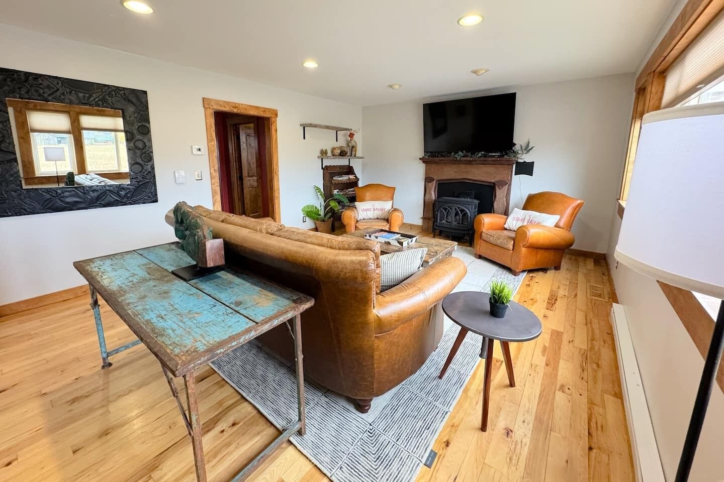 A cozy living room with a brown leather sofa, a small table, and a fireplace.
