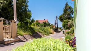 A residential street with a house, a gate, and lush greenery. - Modern 2BR Beach Apartment in Zadar (Zadar)