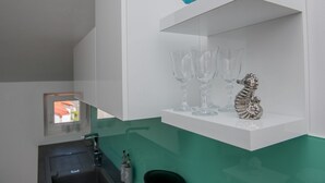 A bathroom with a white sink, a mirror, and a shelf with decorative items. - Modern 2BR Beach Apartment in Zadar (Zadar)