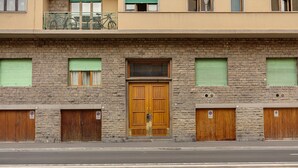 A building with a stone facade, a central wooden door, and shuttered windows. - Mamo Florence - Binario 9 Apartment (Florence)