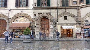 A street with shops, including a pharmacy and a souvenir shop. - Mamo Florence - Cupolone Apartment (Florence)