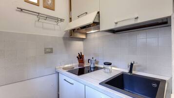 Apartamento, 1 quarto | Cozinha americana privada | Geladeira, micro-ondas, cooktop, talheres/pratos/utensílios de cozinha