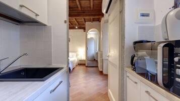 Apartamento, 1 quarto | Cozinha americana privada | Geladeira, micro-ondas, cooktop, talheres/pratos/utensílios de cozinha