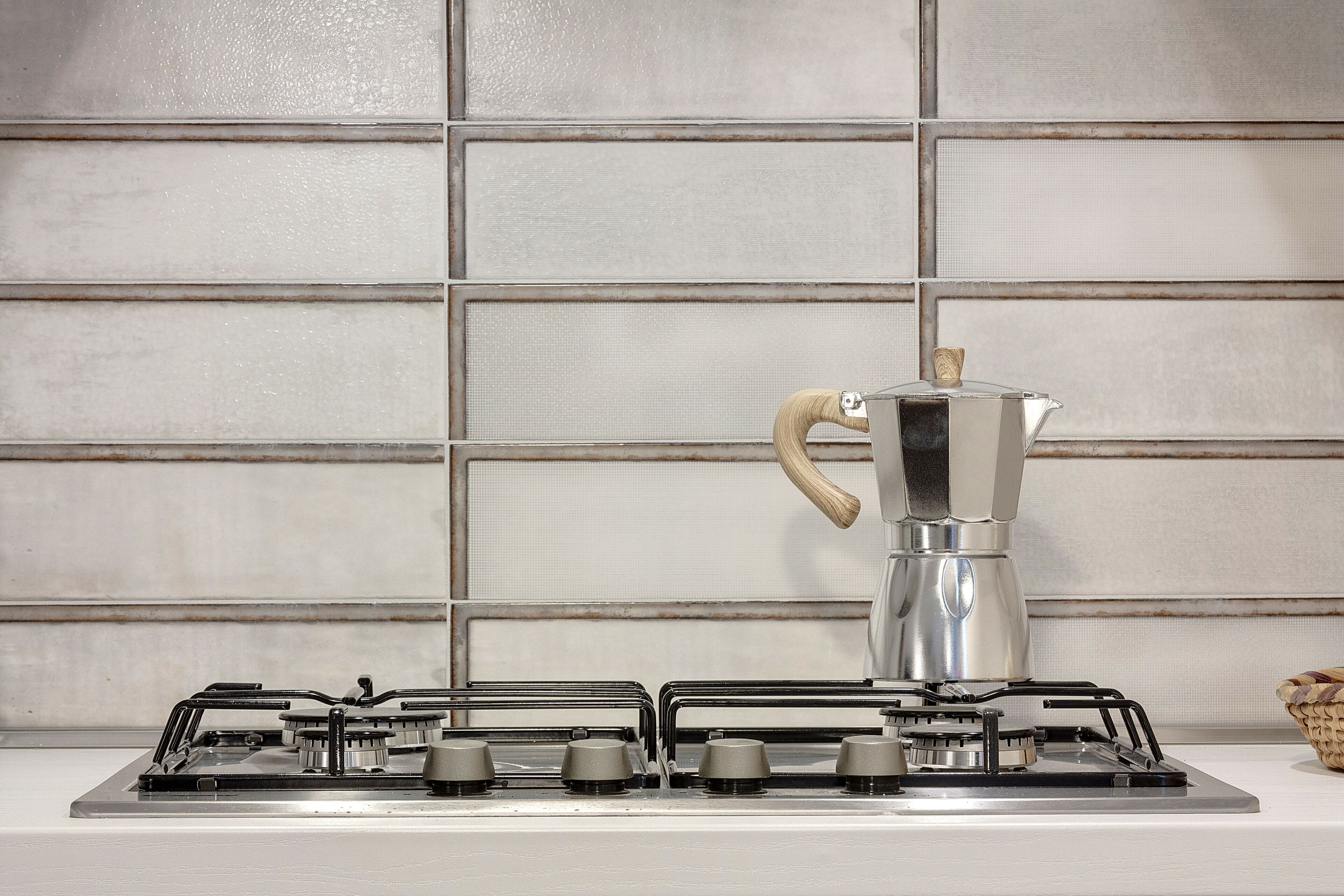 Une cuisine équipée d’une cuisinière à gaz et d’une cafetière.