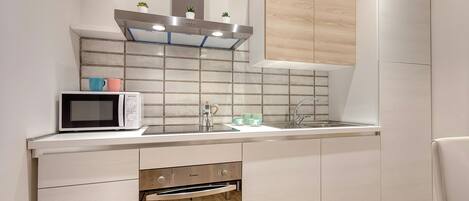 A modern kitchen with a microwave, sink, and built-in oven.