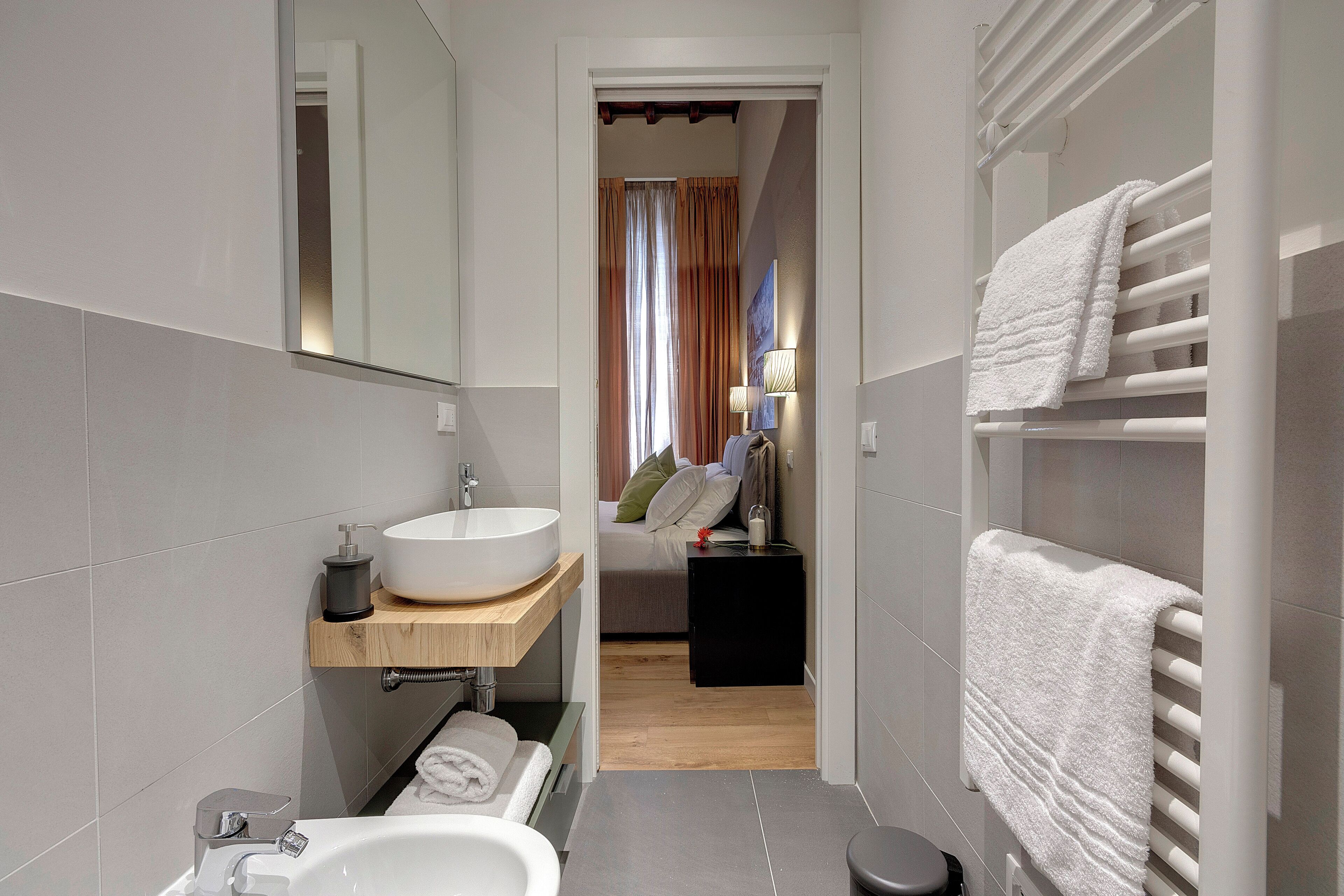 A modern bathroom with a large sink, a bathtub, and a towel rack.