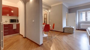 Un appartement moderne comprenant une cuisine, un coin repas et une chambre.