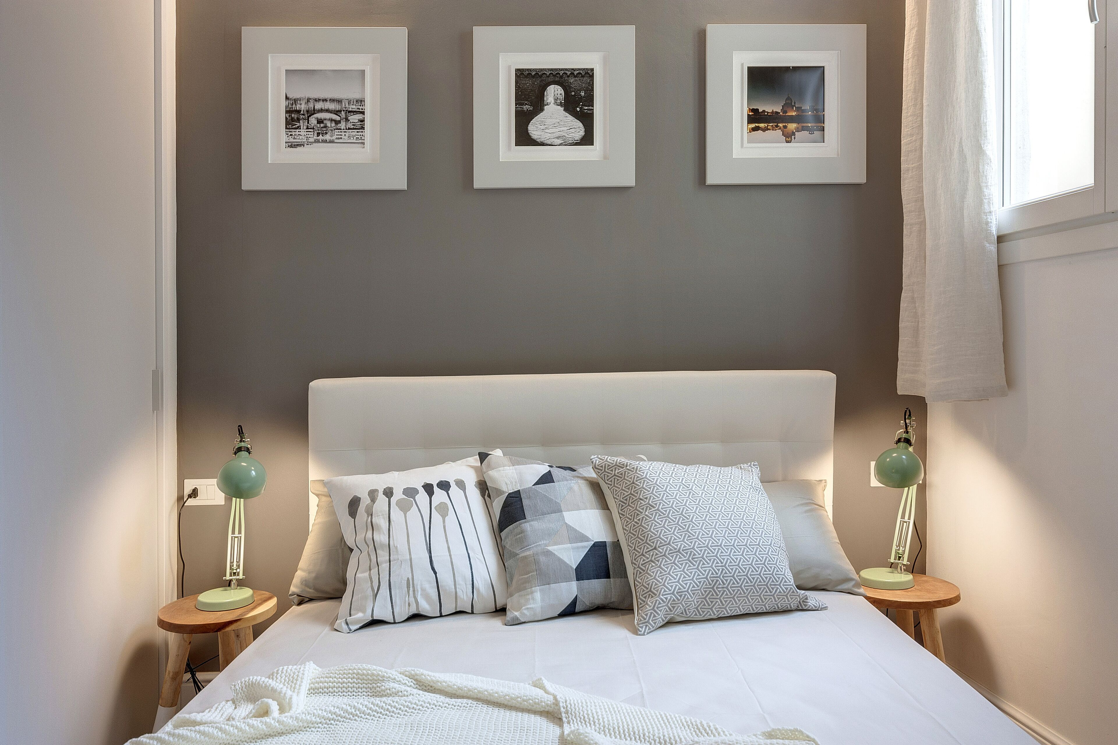 A neatly arranged bedroom with a bed, pillows, and bedside lamps.