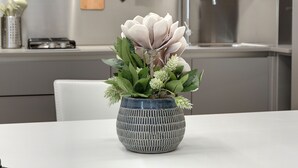 A kitchen with a white table, a blue textured pot with a plant, and a stainless steel sink. - Mamo Florence - St. Elizabeth Loft Apartment (Florence)