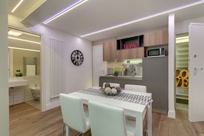 A modern kitchen with a microwave, cabinets, and a 'Home' sign.