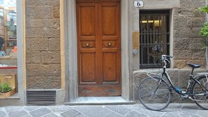 Edifici de pedra amb una porta doble de fusta, una bicicleta aparcada a l'exterior i una petita finestra amb un rètol que diu '6'.