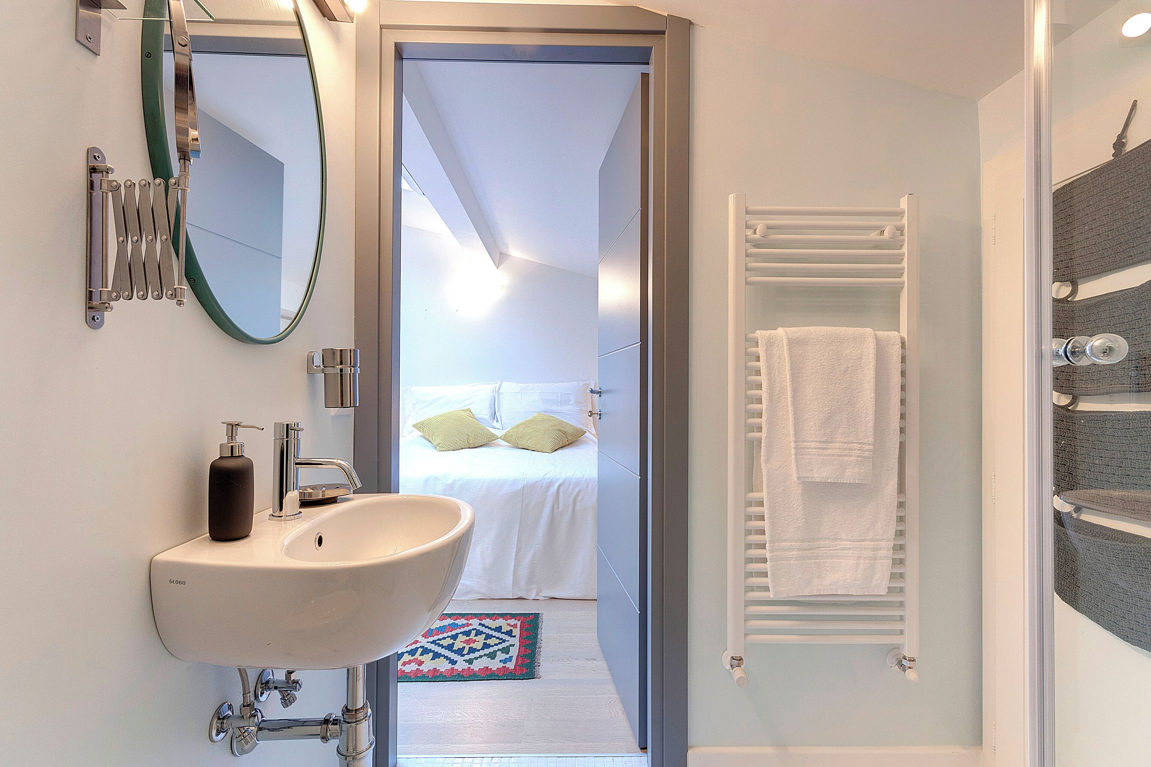 Une salle de bain moderne avec un grand lavabo, un miroir et un espace douche.